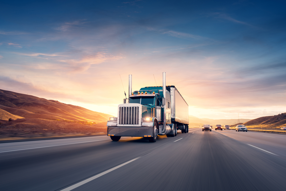 A truck on a highway during the sunset