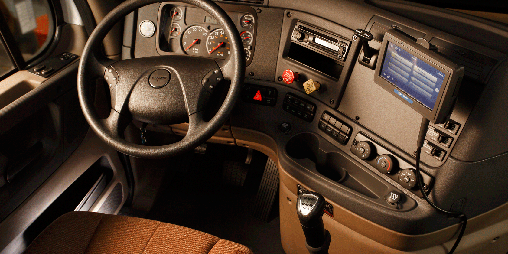 full view of front seat of semi trailer with dash, seat, navigation, and steering wheel